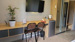 a desk with a television and a chair in a room at Homy House Hotel in Tashkent