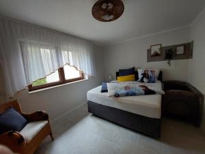 a bedroom with a bed and a chair and a window at Ferienhaus Triebesgrund in Zeulenroda