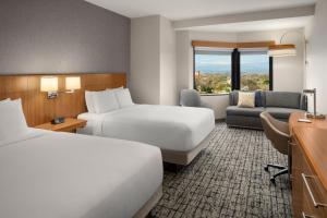 una camera d'albergo con due letti e un divano di Hyatt Place Denver Cherry Creek a Denver