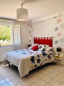 um quarto com uma cama com uma cabeceira vermelha em Emporium Néris - Premium Serviced Apartments em Néris-les-Bains