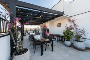 Un patio con mesas y sillas y plantas en macetas. en AA212 Studio sofisticado na Bela Vista, en São Paulo