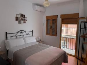 a bedroom with a large bed and a window at El Mercado in Alcaudete