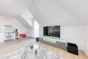 uma sala de estar com uma grande televisão de ecrã plano em Appartement Neuf avec Terrasse em Bobigny