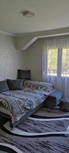 a bedroom with a large bed with a comforter at Drinski odmor ,,Mima,, 1 in Perućac
