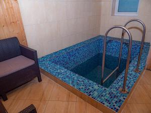 una piscina con azulejos azules en el baño en Оаза en Dragobrat