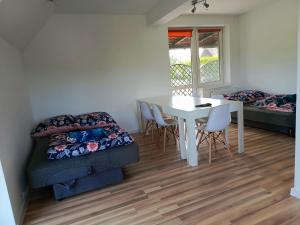 a living room with a table and a couch at W Rajbrocie u Ewusi in Rajbrot