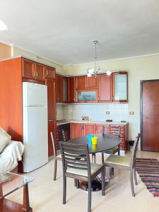 La cuisine est équipée d'une table, de chaises et d'un réfrigérateur. dans l'établissement Ina's Sea View, à Saranda
