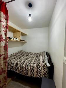 - une petite chambre avec un lit et une lampe dans l'établissement Castel de Roches, à Saint-Gervais-les-Bains