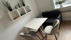 una pequeña oficina con una mesa blanca y sillas en Good Vibes Only, en Cracovia