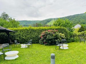 a group of chairs and tables in the grass at Boutique Hotel Pohorje in Maribor