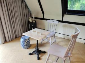 einen weißen Tisch und zwei Stühle in einem Zimmer in der Unterkunft The Lodge At The Creek Haus in Baen