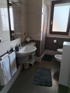 Un baño con lavabo, inodoro y espejo. en Appartamento nuovissimo ad un passo dal mare, en Montesilvano