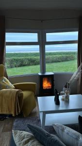 a living room with a fireplace in front of a window at Traumblick Nr 3 aufs Wattenmeer Blick bis nach Texel in Westerland