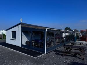 a large white building with a picnic table and tables at Le rêve bleu in Biville-sur-Mer