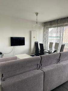 uma sala de estar com um sofá, uma mesa e cadeiras em Schirmeck Apartment em Estrasburgo
