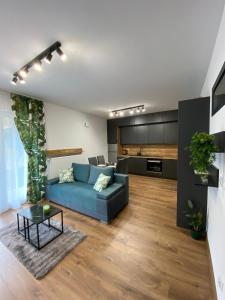 - un salon avec un canapé bleu et une table dans l'établissement EM Room, à Cracovie
