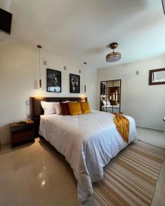 a bedroom with a large white bed with yellow pillows at Hotel Garni Cruzeiro do Sul in Paraty
