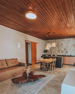 een woonkamer met een bank en een tafel bij Vila Baru in Alto Paraíso de Goiás