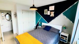 a bedroom with a bed and a black and white wall at La Casita, Your Home Away from Home in Glasgow