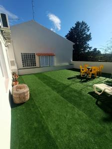 une cour avec de l'herbe verte et des chaises ainsi qu'un bâtiment dans l'établissement Casa Ribes Rooms, l'angolo tranquillo alle porte della città, à Olbia