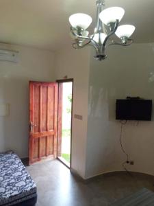 um quarto com uma cama, um lustre e uma porta em Résidence BANA em Ngaparou