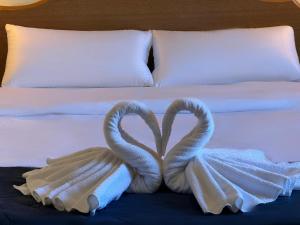 due cigni per asciugamani seduti sopra un letto di Hotel Portofino by InsideHome a Empuriabrava