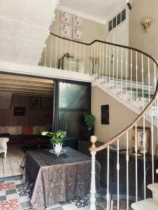 - un salon avec une table et un escalier dans l'établissement Les Lauriers Duplex centre ville avec jardin, à Nyons