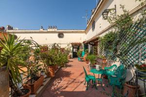 a patio with chairs and tables and potted plants at Farnese Stunning Penthouse | Romeloft in Rome