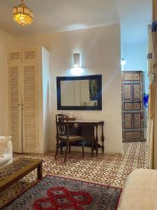a living room with a table and a mirror at Bab El Fen in Tangier