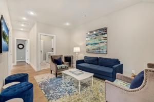 a living room with a blue couch and chairs at The Dogwood-Hot Tub-Lake Front Access in Springdale