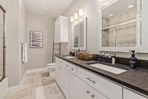 a white bathroom with a sink and a toilet at The Dogwood-Hot Tub-Lake Front Access in Springdale +34 photos