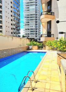 a swimming pool on the roof of a building with tall buildings at Royal Duplex Umarizal in Belém