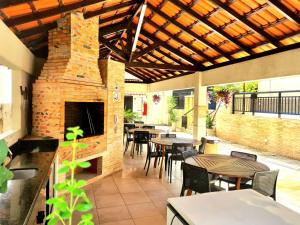 a patio with tables and chairs and a brick fireplace at Royal Duplex Umarizal in Belém