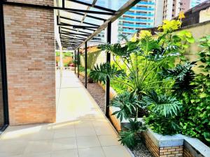 a courtyard in a building with plants and a sidewalk at Royal Duplex Umarizal in Belém