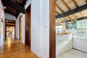 cocina con paredes blancas y techo de madera en Piazza Mattei Elegant Apartment | Romeloft en Roma