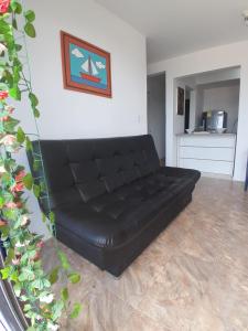 a black leather couch sitting in a living room at Portal de la Sierra Apto 207 in Playa Dormida +2 photos