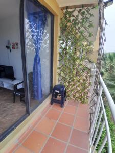 a room with a balcony with a window with a blue curtain at Portal de la Sierra Apto 207 in Playa Dormida
