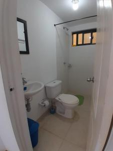 a white bathroom with a toilet and a sink at Portal de la Sierra Apto 207 in Playa Dormida