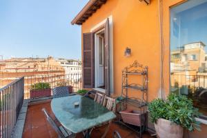 einen Balkon mit einem Tisch und Stühlen in der Unterkunft Trevi Comfortable Apartment with Terrace | Romeloft in Rom