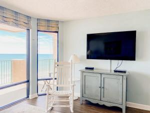 默特尔比奇The Blue Dune Oceanfront Huge Balcony w Lazy River的客厅配有电视、椅子和桌子