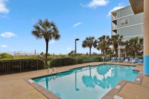 默特尔比奇The Blue Dune Oceanfront Huge Balcony w Lazy River的一座棕榈树游泳池和一座建筑