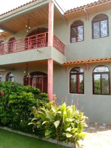 uma casa grande com varanda e algumas plantas em Résidence BANA em Ngaparou