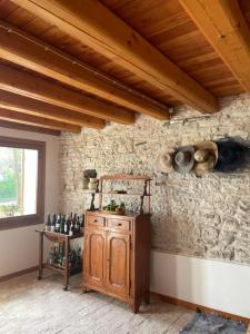 Cette chambre est dotée d'un mur en pierre et d'une table avec des bouteilles de vin. dans l'établissement Vite in Rosa La Casetta, à Valdobbiadene