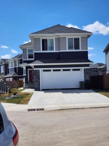 a house with a white garage door in a driveway at Feel At Home in Edmonton