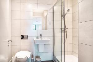 y baño con ducha, lavabo y aseo. en Modern 3 Bedroom Manchester Apartment, en Mánchester