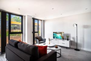 sala de estar con sofá y TV en Modern 3 Bedroom Manchester Apartment, en Mánchester
