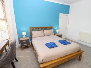 a bedroom with a bed with two blue pillows on it at White Sand in Sandown