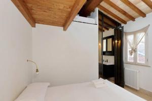 a bedroom with a white bed and a wooden ceiling at Pantheon Stylish Attic in Rome