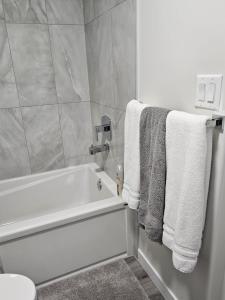 a bathroom with a white bath tub and towels at Feel At Home in Edmonton
