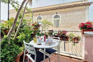 ローマにあるScala Luxury Terrace studioの白いテーブルと椅子、花の咲くバルコニー